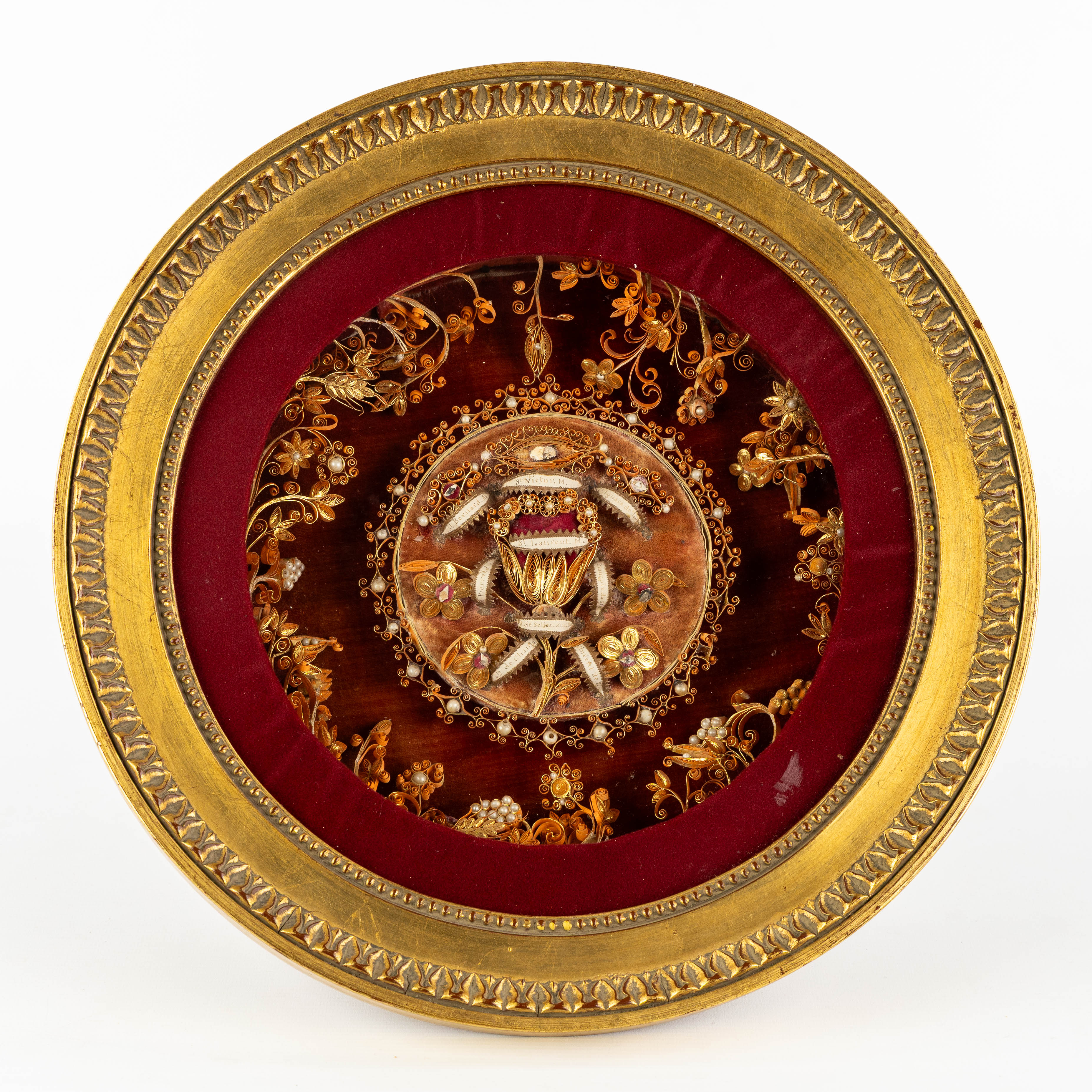 Een rond reliekenkader met relikwieën voor Petrus de Apostel, Heiligen en Martelaren. (L:37.5 x W:12 cm)